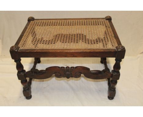 An oak Cromwellian-style rectangular stool with cane work seat on turned supports