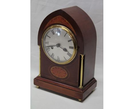 An Edwardian mantel clock with silvered circular dial in inlaid mahogany and brass mounted gothic arched case