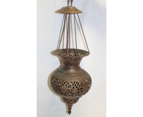 A Middle Eastern bronzed metal hanging oil lamp with pierced decoration