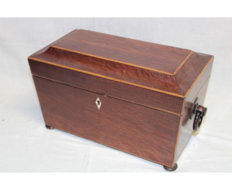 An early 19th century inlaid rosewood sarcophagus-shaped tea caddy with central cut-glass mixing bowl flanked by twin compart