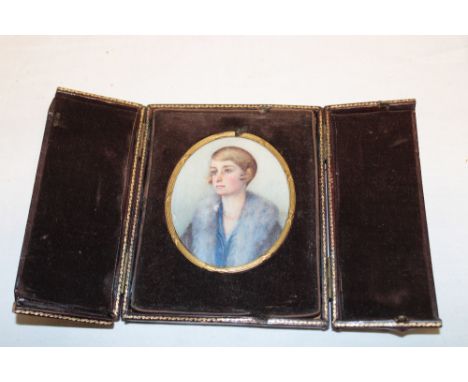 A miniature oval watercolour portrait depicting a bust portrait of a female in gilt and Morocco leather folding case