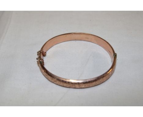 A 9ct gold engraved oval bangle (10g)
