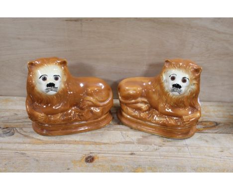 A PAIR OF VICTORIAN STAFFORDSHIRE STYLE CERAMIC LION FIGURES