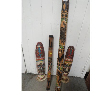 TWO ABORIGINAL STYLE DIGERIDOOS TOGETHER WITH TWO TRIBAL WALL MASKS 