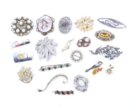 A collection of lady's brooches. Including one decorated with a ceramic panel, another with mother of pearl inlay, modelled a