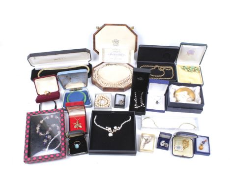 An assortment of boxed items of jewellery. Including a 22ct gold plated brooch, a string of imitation pearls, jade bangle, et