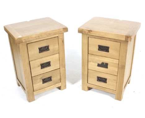 A pair of modern light oak bedside chests of drawers. Each having three drawers with metal handles. H66cm x W45cm x D38