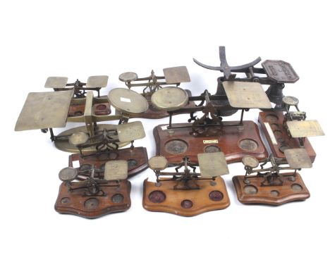 A collection of postal scales. Mostly unbranded brass examples mounted on oak bases, weights missing