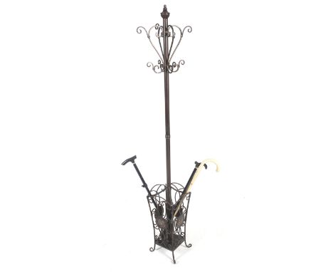 A contemporary metal coat/umbrella stand. With metal work cage base on four scroll feet. Comes with three walking sticks. H18