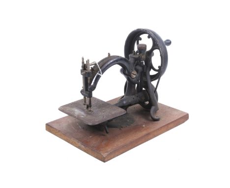 A vintage Willcox & Gibbs hand crank sewing machine. Mounted on a base board. H24cm
