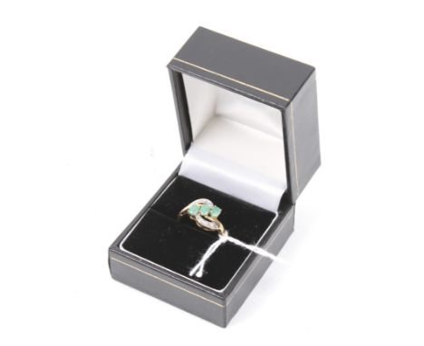 A vintage pale and opaque emerald and rose diamond cross-over ring. Centred with three round mixed-cut emeralds within rose d