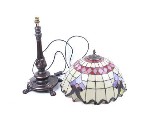 A Tiffany style table lamp. Having a metal finial top, a domed leaded glass shade mounted on a carved wooden stand. H35cm