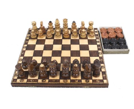 A carved wooden chess set and a box of vintage draughts. The chess pieces in a wooden box which doubles as a board, the draug