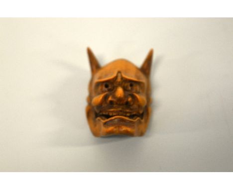 A JAPANESE BOXWOOD MASK NETSUKE, depicting Hannya, the demon carved with open mouth and upright horns, the reverse with an in