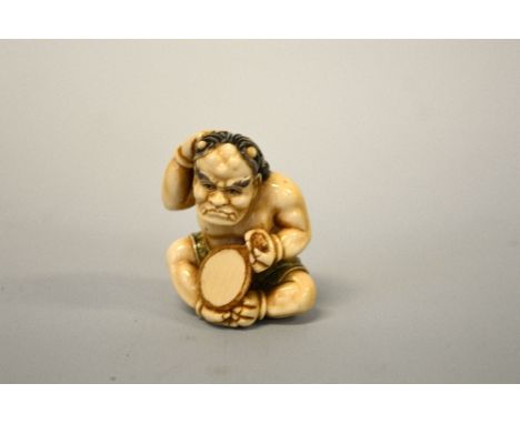 A JAPANESE IVORY NETSUKE, depicting Kyogen looking into a mirror, signed to base