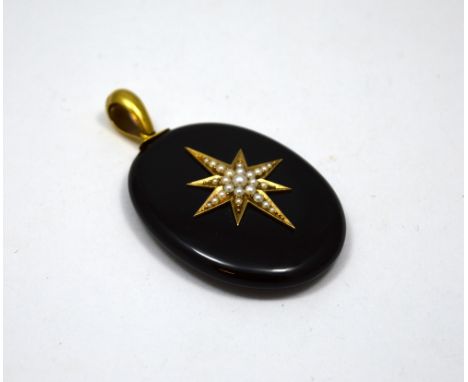 A MEMORIAL LOCKET, designed as an oval shaped black enamel panel with large star to the front with split pearl detail to the 