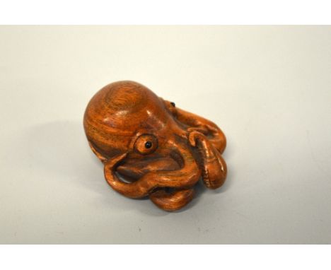 A JAPANESE BOXWOOD NETSUKE, of an Octopus, the eyes inlaid, signed to rear