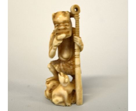 A JAPANESE IVORY NETSUKE, depicting kyogen and a Dog, signed to base