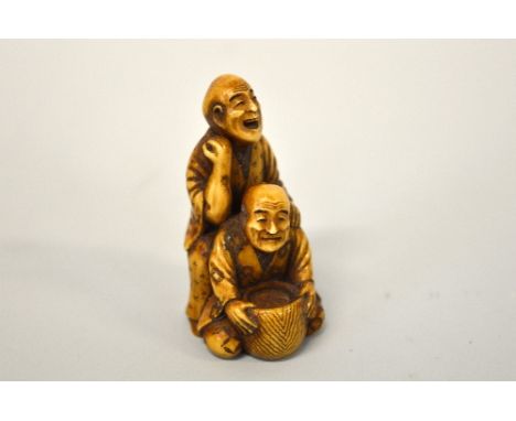 A JAPANESE BOXWOOD NETSUKE, carved as men at work, signed to base