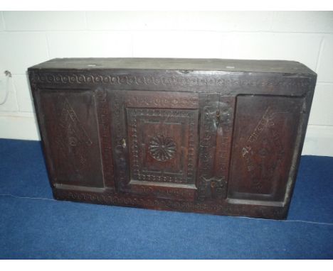 AN 18TH CENTURY CARVED OAK HANGING CUPBOARD, with central door flanked by panels carved with diamond motif, the interior with