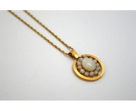 A 9CT GOLD OPAL PENDANT, with large oval opal cabochon within a surround of smaller circular opals to a diamond cut circular 