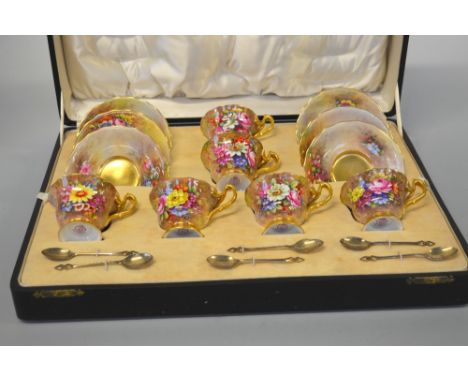 A CASED SET OF SIX ROYAL WORCESTER COFFEE CUPS AND SAUCERS, with wavy rims, hand painted with floral sprays on gilt, signed E