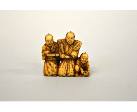 A JAPANESE IVORY NETSUKE, carved as scholars, signed to base