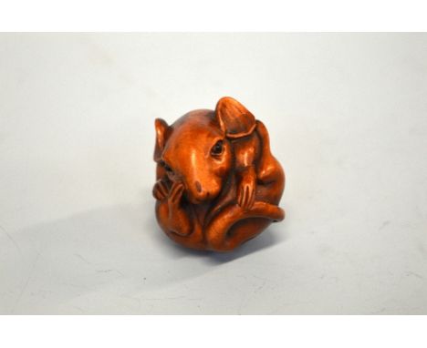 A JAPANESE BOXWOOD NETSUKE, of a Rat, curled into a ball, the eyes inlaid, signed to the base