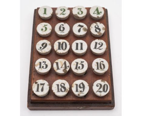 A set of early 20th century ceramic gaming counters numbered 1-20 in a wooden plinth:, 12.5cm x 9cm