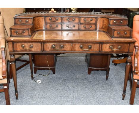 A Mahogany Carlton House Style Desk, early 20th century, with pierced brass gallery, leather inset top, and raised on turned 