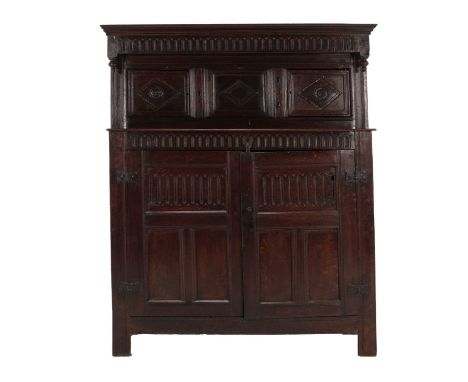 A 17th Century Joined Oak Press Cupboard, the nulled frieze above two moulded cupboard doors with lozenge carved panels and a