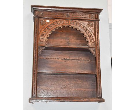 A 18th Century Oak Hanging Shelf, moulded cornice above a carved arch and with three open shelves, 60cm by 13cm by 81cm