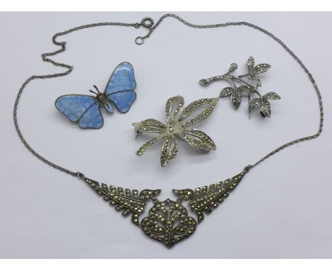 A silver and marcasite necklace, an enamel butterfly brooch and two other brooches