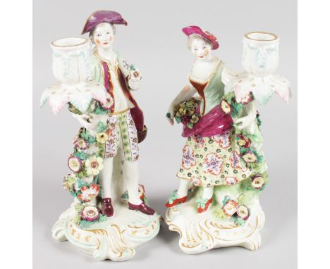 A PAIR OF "CHELSEA DERBY" CANDLESTICK FIGURES of a young lady and man with fruit, and flower encrusted scrolling candle branc