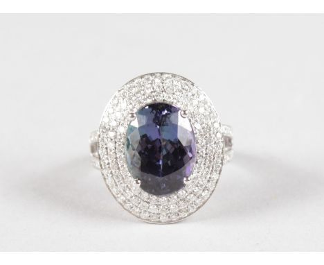 A SUPERB 14CT WHITE GOLD, TANZANITE AND DIAMOND CLUSTER RING, set with a 6.72ct tanzanite and 1.50ct of diamonds.