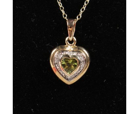 A 9CT YELLOW GOLD HEART SHAPED PERIDOT AND DIAMOND PENDANT AND CHAIN.