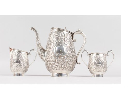AN INDIAN SILVER THREE PIECE TEA SET with all-over decoration, teapot, sugar basin and milk jug. Weight 27ozs.