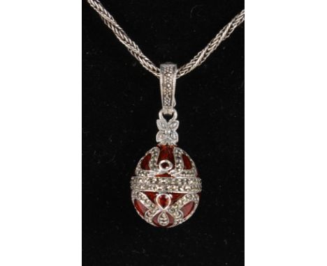 A FABERGE STYLE SILVER, MARCASITE, ENAMEL AND GARNET SET PENDANT on a silver chain.