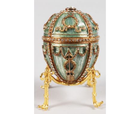 THE FABERGE COLLECTION. A LOVELY ENAMEL AND BRILLIANT SET FABERGE EASTER EGG AND STAND in original box.