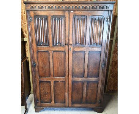 An Ercol linenfold design wardrobe