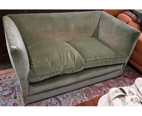 A traditional box style two-seater sofa in green velour upholstery - by repute from the mansion flats where Poirot was filmed