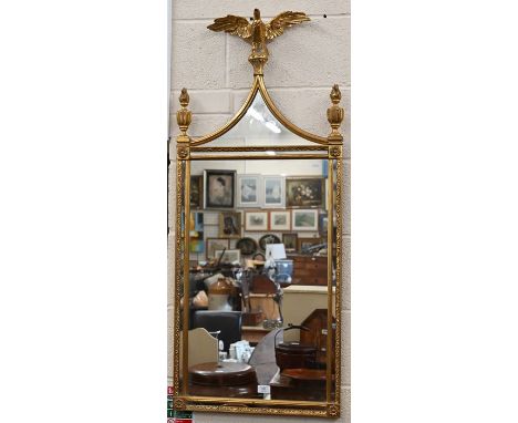 A late 20th century decorative gilt framed wall mirror surmounted with central eagle and pair of urn finials, 120 x 51 m