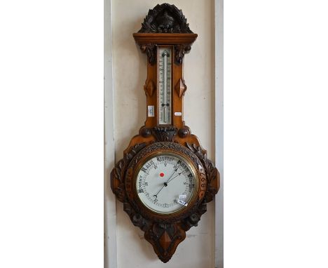 A Victorian walnut wheel barometer 'patent no 16538' carved with VR Royal Cypher and decorative rose and thistle garlands, gl