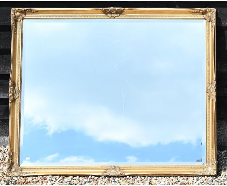 A large bevelled rectangular wall mirror in decorative gilt gesso frame, 126 cm wide x 104 cm high