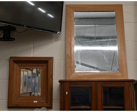 A rectangular wall mirror in moulded stained pine frame, 55 x 50 cm to/w a bevelled mirror in light oak frame, 92 x 68 cm (2)