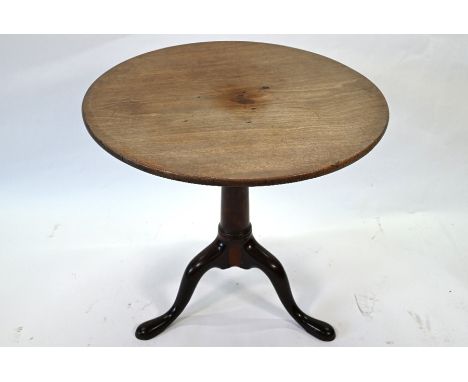A George III mahogany tripod table, the oval tilt top over a four pillar 'birdcage' and gun barrel support to pad feet, 65 cm