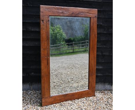 A large bevelled rectangular mirror in rustic stained hardwood frame, 176 x 120 cm overall