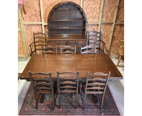 An Ercol extending dining table and eight chairs (pads to be removed) to/with an Ercol dresser