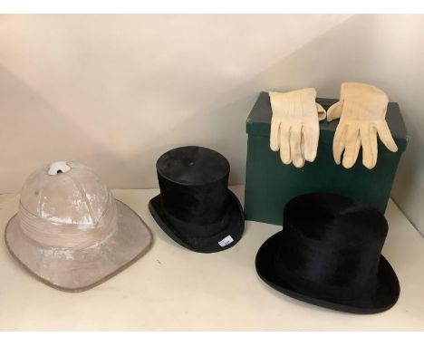 Two top hats, one in fitted green case, and a Pith helmet, all with wear 