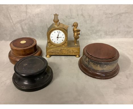 A French gilt metal mantle clock, and three turned wooden bases or socles 